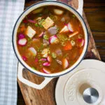 Overhead close-up Korean beef doenjang jjigae stew with vegetables and tofu in it's cooking pot.