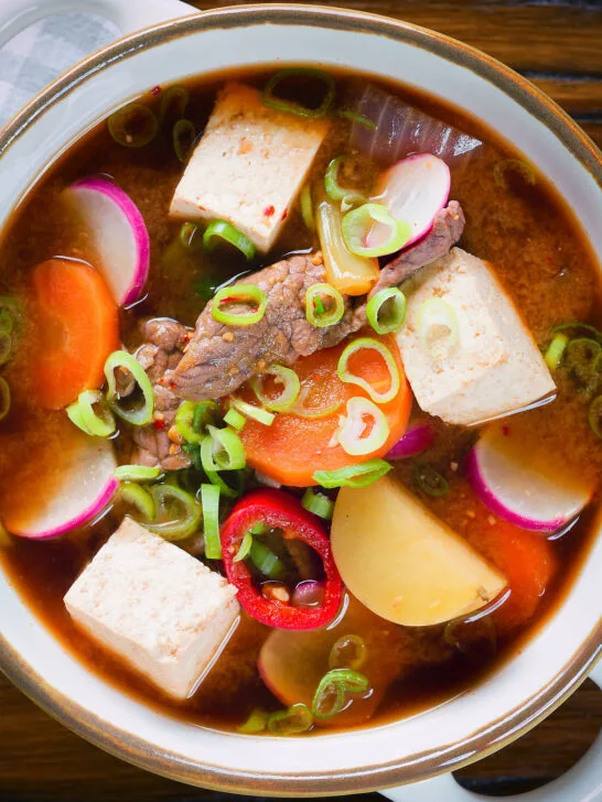 Overhead close-up Korean beef doenjang jjigae stew with vegetables and tofu.