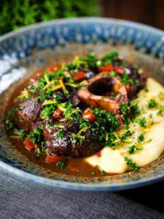 Beef shin (shank) osso buco served with polenta and gremolata.