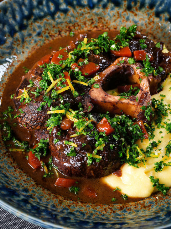 Close-up beef shin (shank) osso bucco served with polenta and gremolata.
