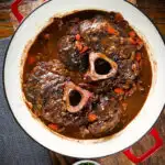 Overhead beef shin (shank) osso buco served in its cooking pan.