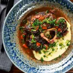 Overhead beef shin (shank) osso buco served with polenta and gremolata.