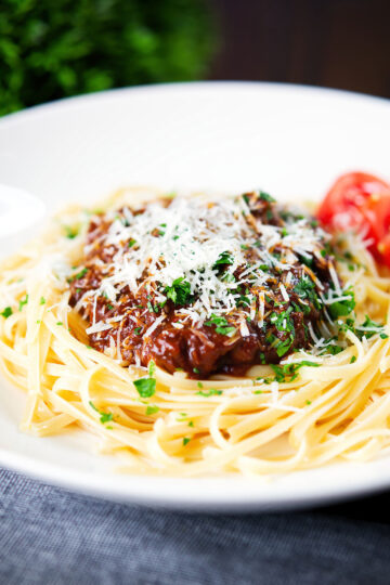 Beef pastitsada (Corfu) served with linguine pasta and tomato wedges and parmesan.