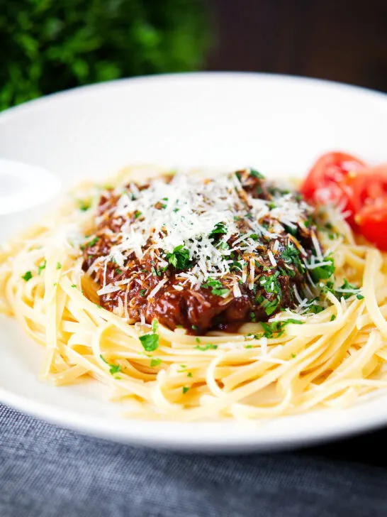 Beef pastitsada (Corfu) served with linguine pasta and tomato wedges and parmesan.