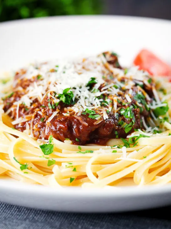 Close-up beef pastitsada (Corfu) served with linguine pasta and tomato and parmesan.