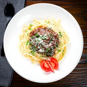 Beef pastitsada from Corfu served with linguine and tomato wedges.