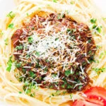 Close-up overhead beef pastitsada (Corfu) served with linguine pasta and tomato and parmesan.