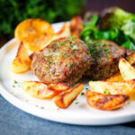 Baked Greek bifteki patties with lemon roasted potato wedges and salad.