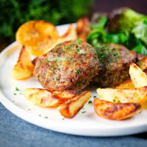 Baked Greek bifteki patties with lemon roasted potato wedges and salad.