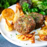 Baked Greek bifteki patties with lemon roasted potatoes and salad.