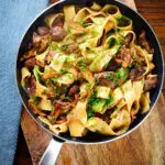 Overhead chicken liver and mushroom pasta with sage, balsamic vinegar and butter in a pan.