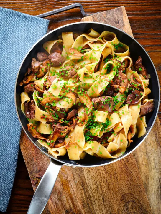 Overhead chicken liver and mushroom pasta with sage, balsamic vinegar and butter in a pan.