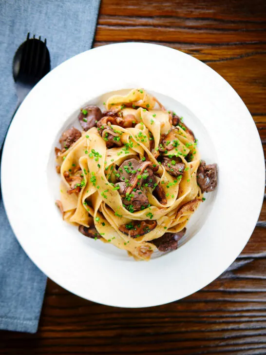 Overhead chicken liver and mushroom pasta with sage, balsamic vinegar and butter.