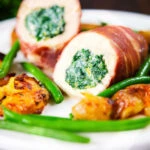 Chicken wrapped in Parma ham stuffed with spinach and ricotta served with roasted new potatoes and green beans.