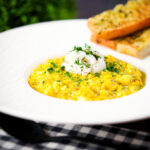 Tinned crab and saffron risotto served with dill and garlic bread.