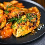 Mango chutney chicken breast garnished with coriander and served with masala chips.