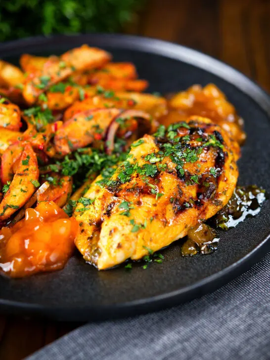 Mango chutney chicken breast garnished with coriander and served with masala chips.