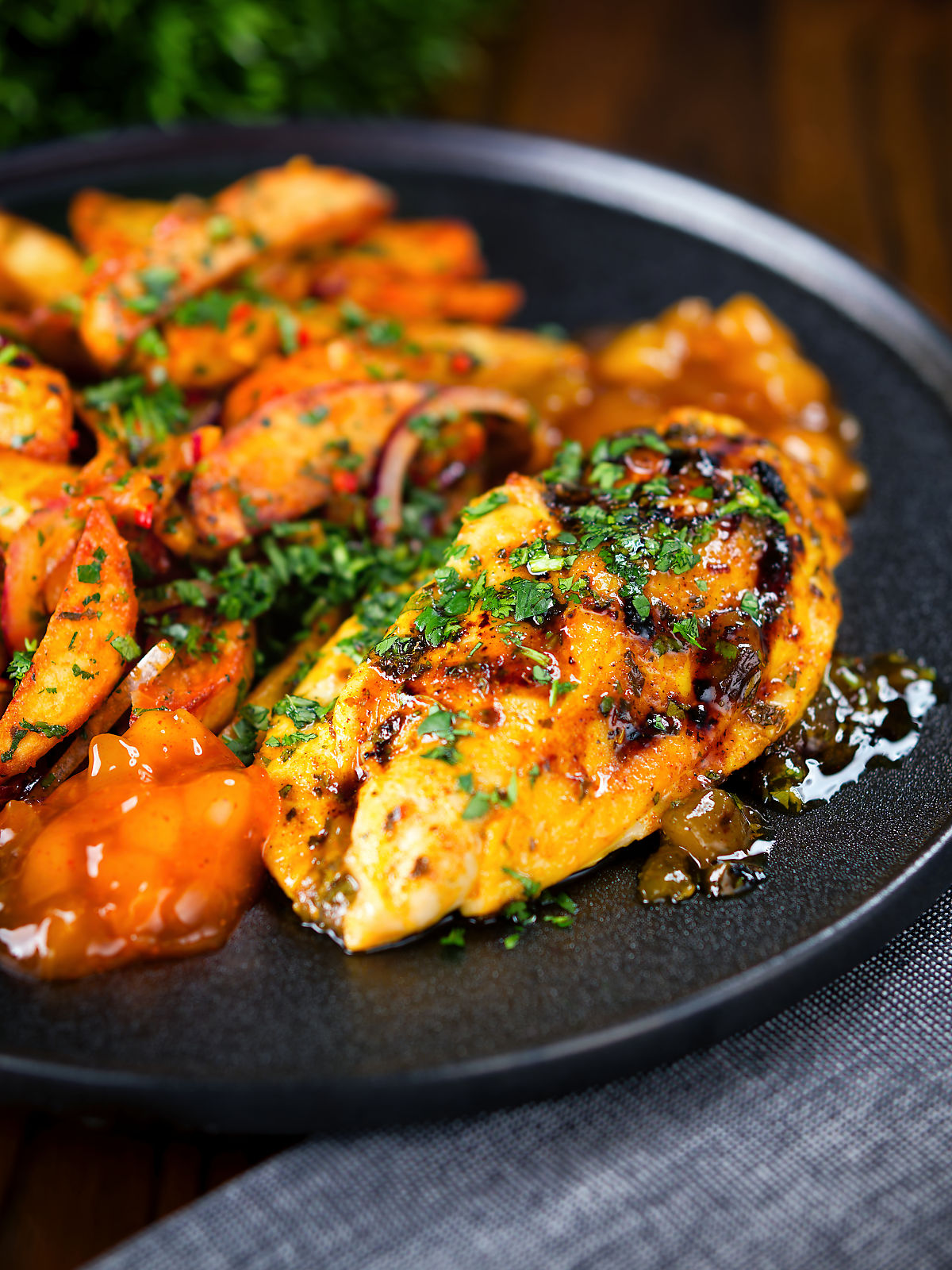 Mango chutney chicken breast garnished with coriander and served with masala chips.