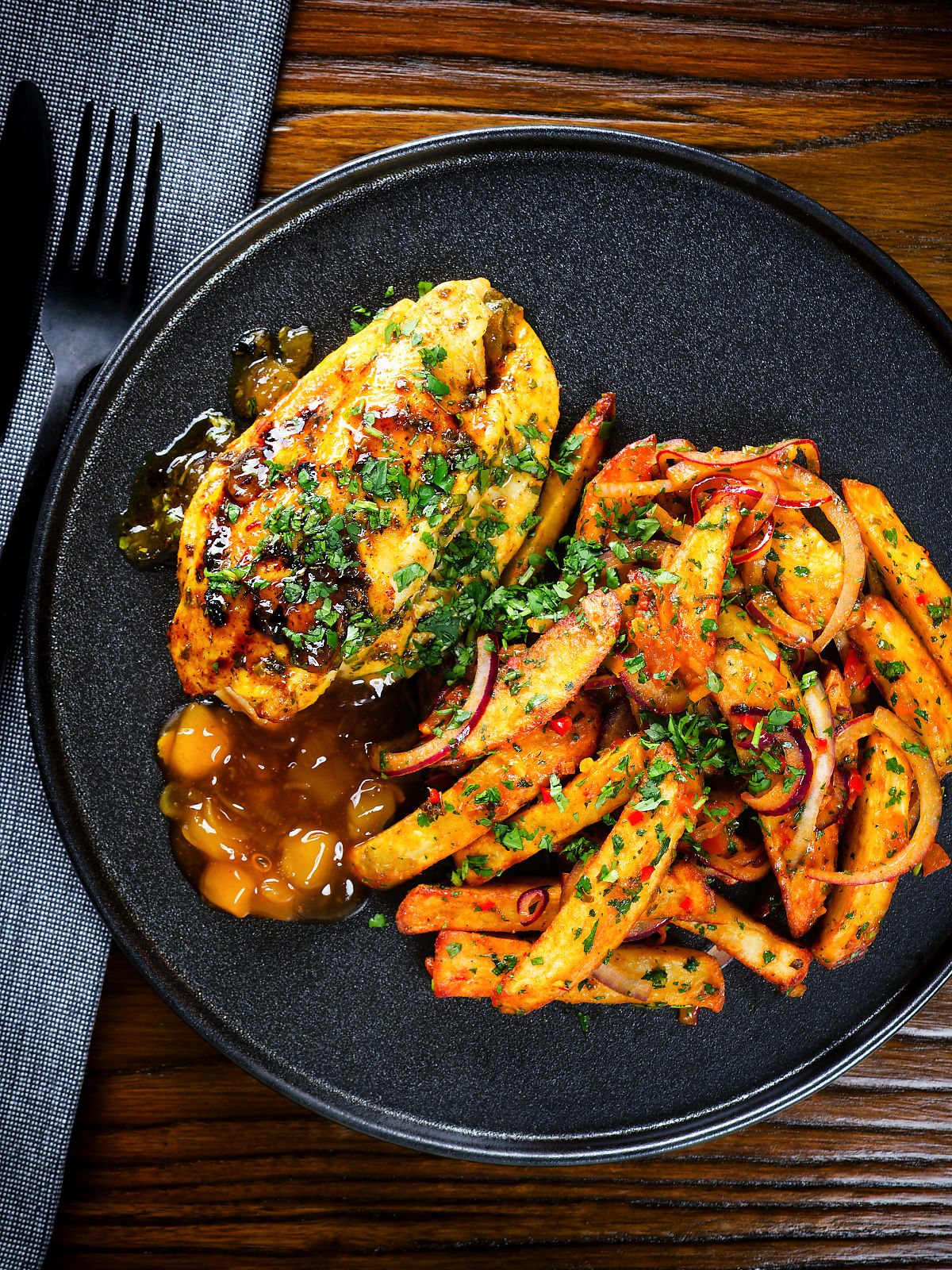 Overhead mango chutney chicken breast served with masala chips.