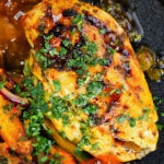 Close-up overhead mango chutney chicken breast served with masala chips.
