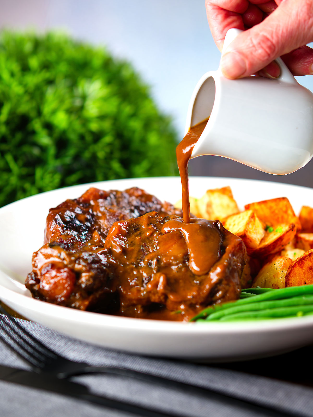 "Gravy" poured over Spanish-influenced braised oxtail (rabo de toro) served with green beans and potatoes.