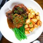 Overhead Spanish-influenced braised oxtail (rabo de toro) with mini roast potatoes and fine beans.