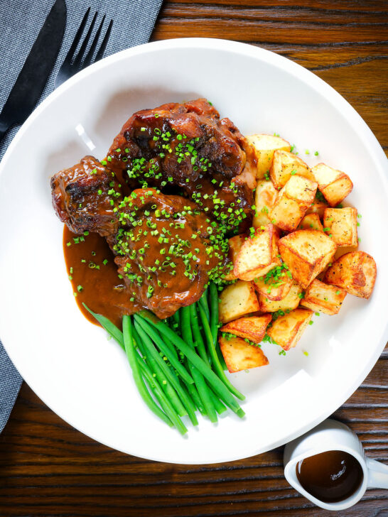 Overhead Spanish-influenced braised oxtail (rabo de toro) with mini roast potatoes and fine beans.