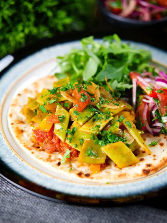 Taze fasulye (Turkish green bean stew) served on flatbread with piyaz salad.