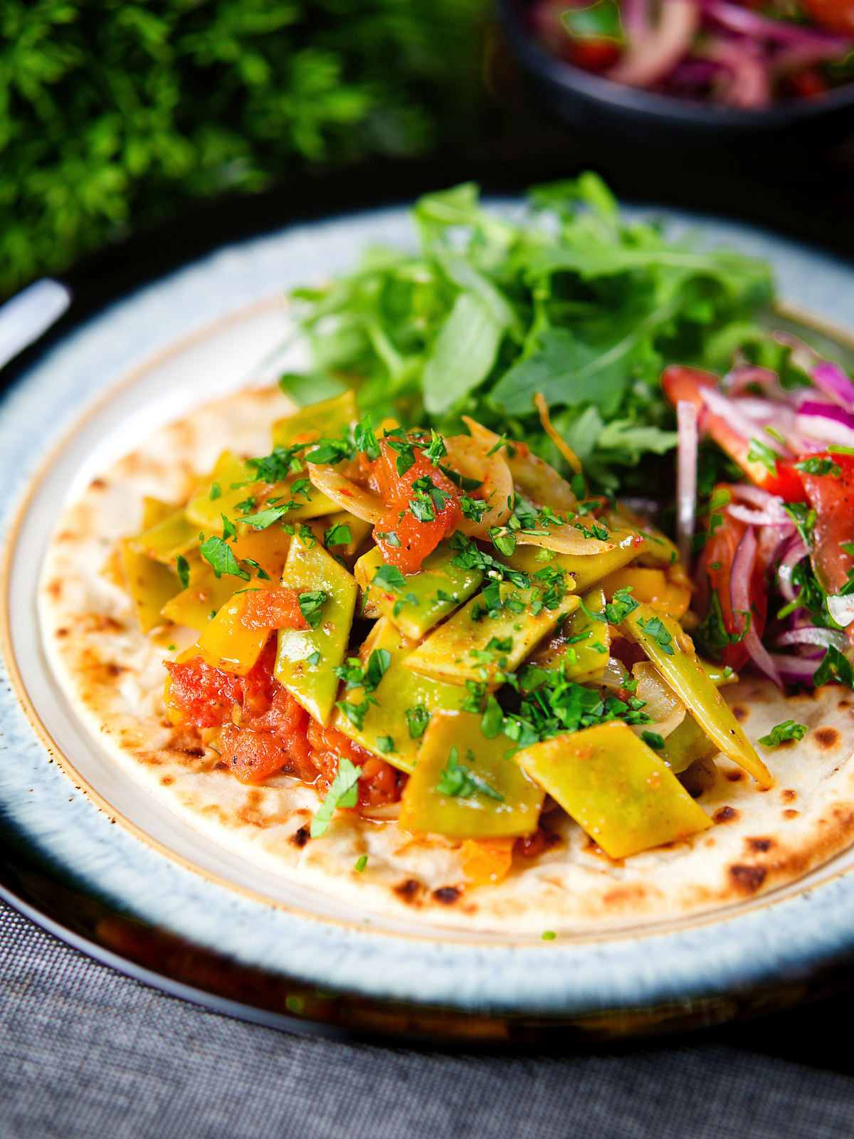 Taze fasulye (Turkish green bean stew) served on flatbread with piyaz salad.