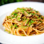 Vegetarian miso mushroom pasta (spaghetti) with snipped chives.