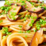 Close-up vegetarian miso mushroom pasta (spaghetti) with snipped chives.
