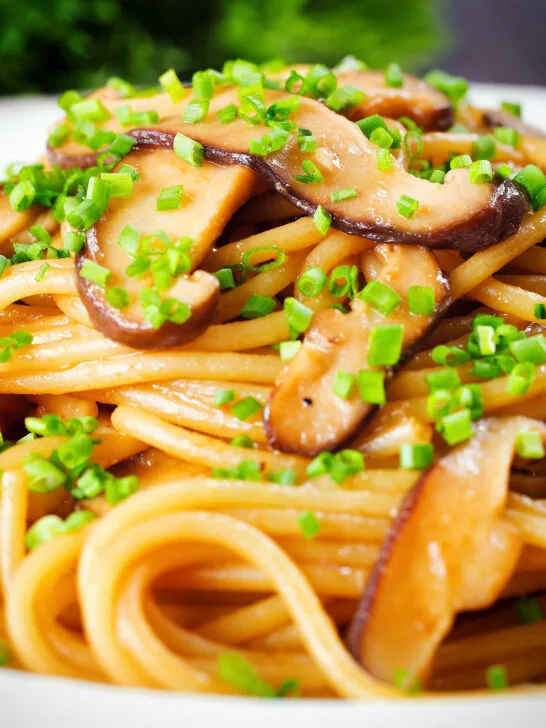 Close-up vegetarian miso mushroom pasta (spaghetti) with snipped chives.