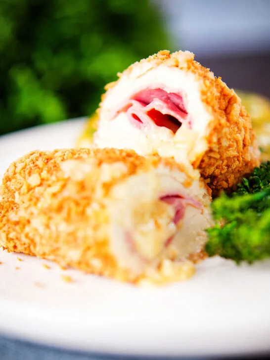 Close-up air fryer chicken cordon bleu with buttered potatoes and broccoli.