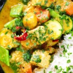 Close-up overhead sayur kare, a Balinese vegetable and tofu curry served with Jasmine rice and fresh coriander.