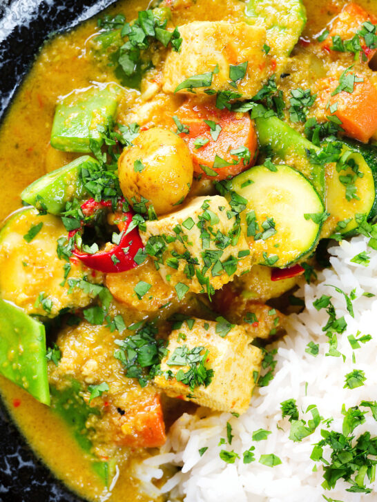 Close-up overhead sayur kare, a Balinese vegetable and tofu curry served with Jasmine rice and fresh coriander.