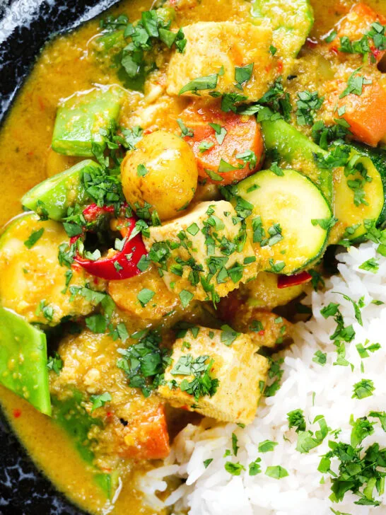 Close-up overhead sayur kare, a Balinese vegetable and tofu curry served with Jasmine rice and fresh coriander.