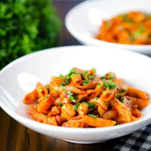 Spicy curry chicken (penne) pasta with Indian influences garnished with coriander.