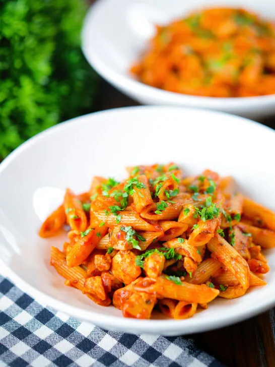 Spicy curry chicken pasta with Indian influences garnished with coriander.