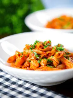 Curry tomato chicken pasta with Indian influences garnished with coriander.