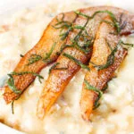Close-up pear, walnut and Gorgonzola risotto with fried pear slices.