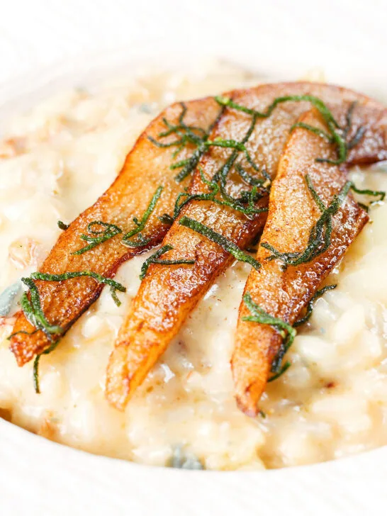 Close-up pear, walnut and Gorgonzola risotto with fried pear slices.