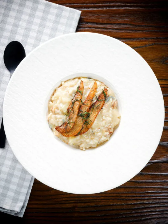 Overhead pear, walnut and Gorgonzola risotto with fried pear slices.