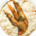 Close-up overhead pear, walnut and Gorgonzola risotto with fried pear slices.