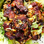 Close-up overhead crispy Chinese salt and pepper pork belly bites with pak choi and Jasmine rice.
