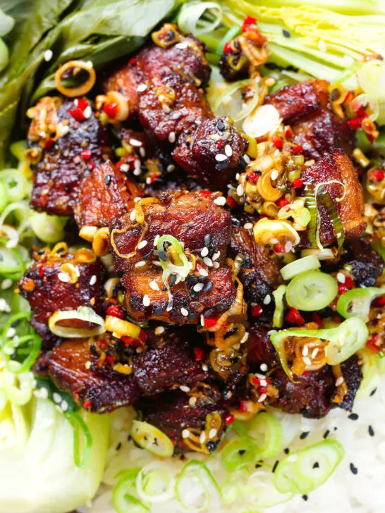 Close-up overhead crispy Chinese salt and pepper pork belly bites with pak choi and Jasmine rice.