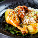 Chinese influenced soy sauce braised chicken leg with pak choi and rice.