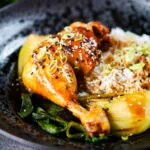 Chinese influenced soy sauce braised chicken leg with pak choi and rice.