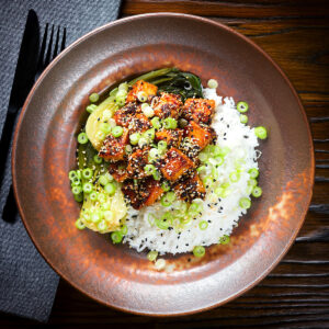 Spicy sticky sesame tofu (vegan) served with pak choi and jasmine rice.