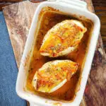 Overhead sticky orange marmalade roasted chicken breasts with fennel seeds in a baking dish.