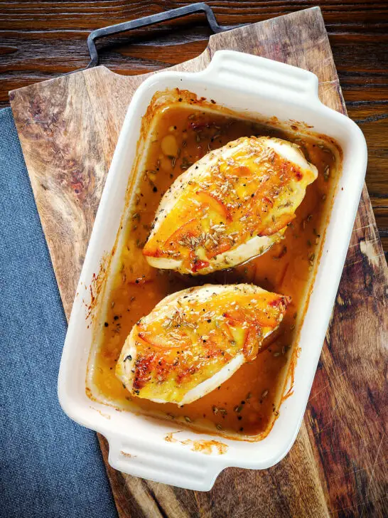 Overhead sticky orange marmalade roasted chicken breasts with fennel seeds in a baking dish.
